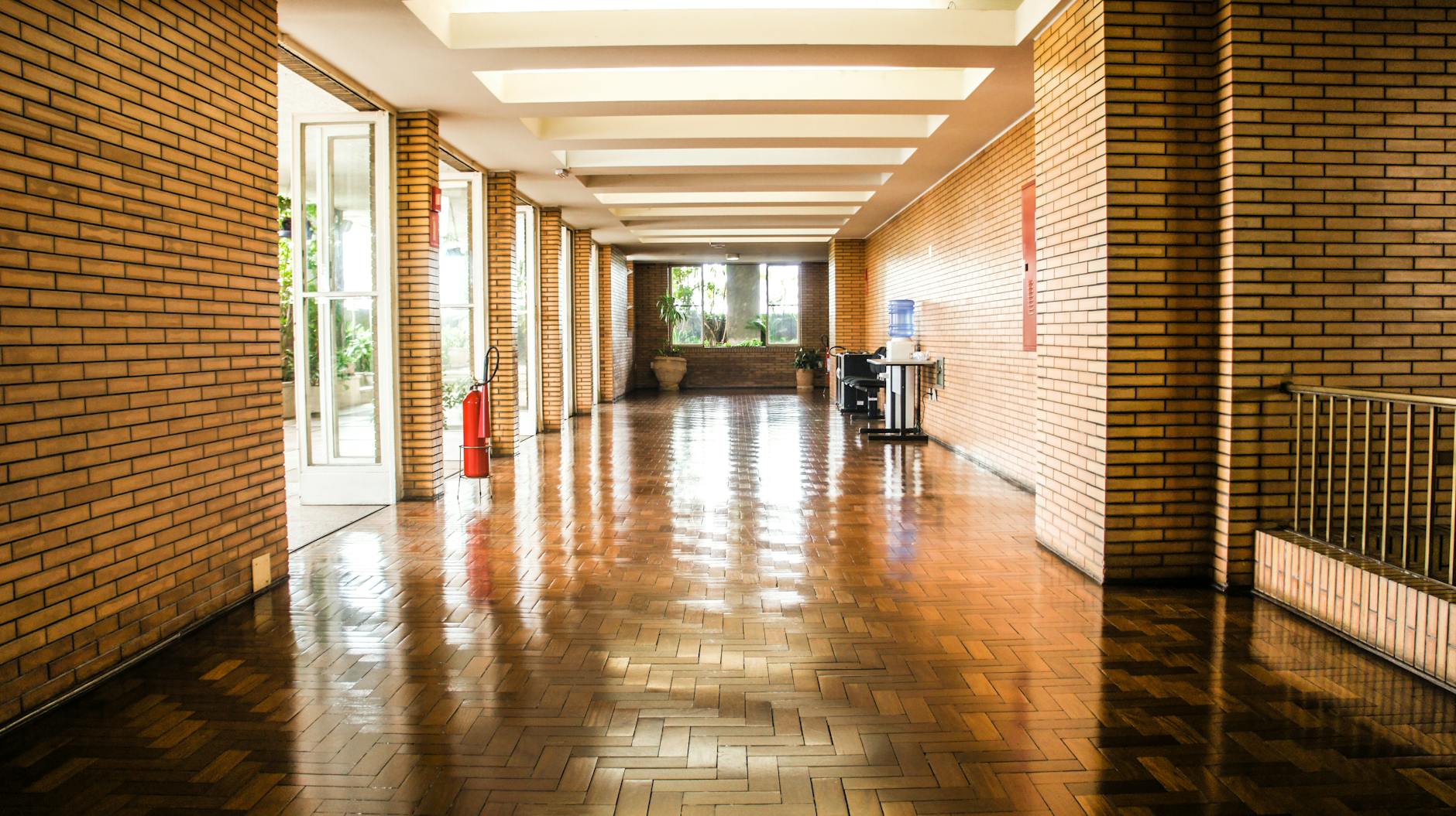 Empty brick corridor in Sé, São Paulo with polished floors and natural light.